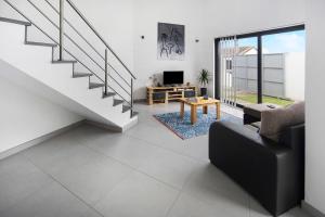 a living room with a staircase and a couch and a table at Casa Caminho da Esperança in Porto Judeu