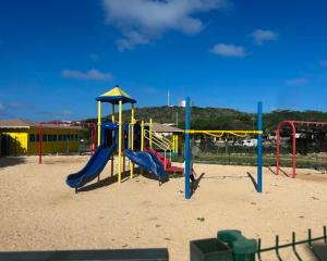 a playground with a slide in the sand at Happy stay297 in Paradera
