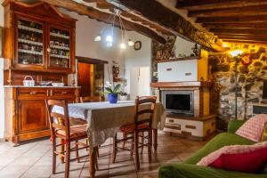 a kitchen with a table and chairs and a fireplace at Querciagrossa da Dora in Roccastrada