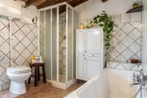 a bathroom with a white tub and a toilet at Querciagrossa da Dora in Roccastrada +23 photos