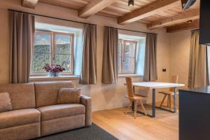 a living room with a couch and a table at Egger an der Lahn - Apt Wald in San Genesio Atesino