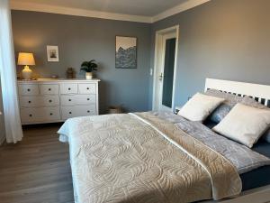 a bedroom with a large bed and a dresser at Ferienwohnung am Waldesrand in Heringsdorf