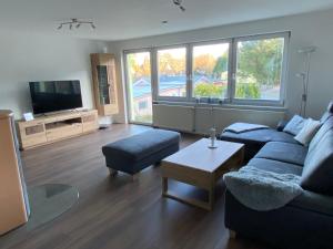 a living room with a blue couch and a tv at Ferienwohnung am Waldesrand in Heringsdorf