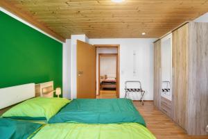 a bedroom with a green wall and a bed at Ferienwohnung Annette in Gomadingen