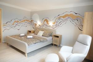 a bedroom with a bed with a mural on the wall at Haevn Erholung, Feuer, Wasser, Luft in Reußenköge