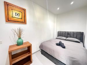 a bedroom with a bed and a vase on a table at Mujito4 16PAX 4BR 1 Min To ECM KCM, BBQ PIT, PS4, Netflix in Kuantan