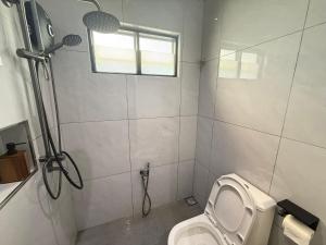 a bathroom with a shower and a toilet and a window at Mujito4 16PAX 4BR 1 Min To ECM KCM, BBQ PIT, PS4, Netflix in Kuantan +23 photos