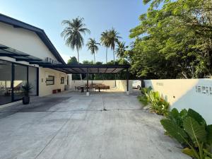 an open patio with a table and palm trees at Mujito4 16PAX 4BR 1 Min To ECM KCM, BBQ PIT, PS4, Netflix in Kuantan