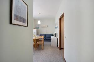 a living room with a table and a blue couch at Appartamento Orizzonte 3 A in Diano Marina