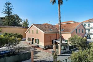 a view of a house with a palm tree at Appartamento Orizzonte 3 A in Diano Marina