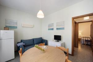 a living room with a table and a blue couch at Appartamento Orizzonte 3 A in Diano Marina