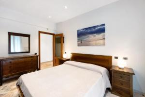 a bedroom with a bed and a dresser and a mirror at Le Vele in Albissola Marina