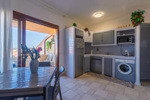 a kitchen and dining room with a table and a kitchen with a washing machine at L'incanto in Palau