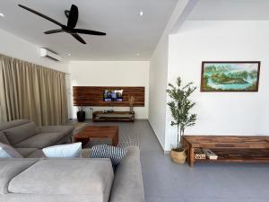 a living room with a couch and a ceiling fan at Mujito4 16PAX 4BR 1 Min To ECM KCM, BBQ PIT, PS4, Netflix in Kuantan