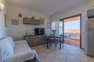 a living room with a couch and a table with a television at L'incanto in Palau