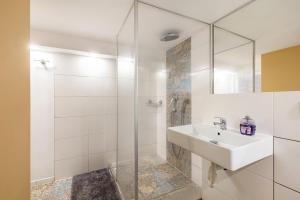 a white bathroom with a sink and a shower at Living the Green in Friedrichsdorf +20 photos