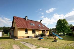 a house with a slide and a playground at Ferienhaus Engert mit Holzofensauna in Althüttendorf