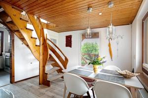a dining room with a table and chairs and a staircase at Ferienhaus Engert mit Holzofensauna in Althüttendorf