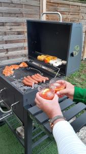a person is cooking hot dogs on a grill at Haus am Ring in Spielberg
