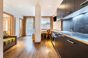 a kitchen and living room with a sink and a couch at Apartments Marialisa Superior Orchi in Chiusa