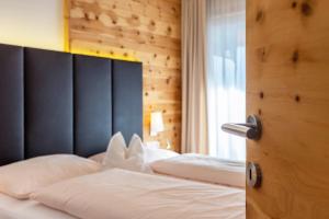 a bedroom with two white beds with a black headboard at Apartments Marialisa Superior Orchi in Chiusa