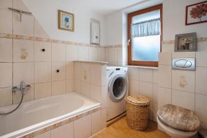 a bathroom with a tub and a washing machine at Ferienhaus Sundperle in Stralsund