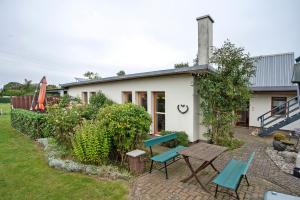 a house with a table and chairs in the yard at Ferienhaus Sundperle in Stralsund