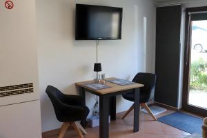 a small table with chairs and a television on a wall at Haus Meereswelle in Büsum
