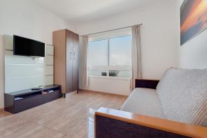 a living room with a couch and a large window at apto luminoso lagos del cotillo in La Oliva