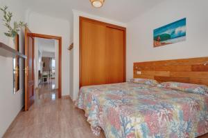 a bedroom with a bed and a wooden headboard at apto luminoso lagos del cotillo in La Oliva