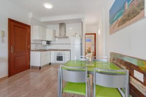 a kitchen with a green table and chairs at apto luminoso lagos del cotillo in La Oliva