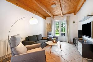 a living room with a couch and a tv at Green Oasis Ferienwohnung in Treia