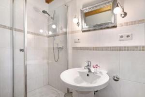 a white bathroom with a sink and a shower at Green Oasis Ferienwohnung in Treia +11 photos