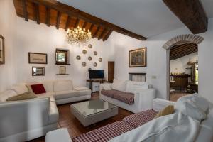 a living room with white furniture and a chandelier at La Petrosa in Radda in Chianti