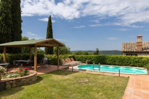 a backyard with a swimming pool and a gazebo at La Petrosa in Radda in Chianti