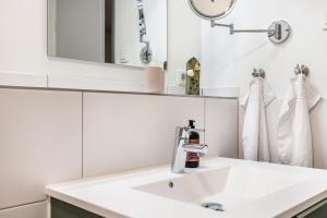 a white bathroom with a sink and a mirror at Grötacker Wohnung 6 in Husby