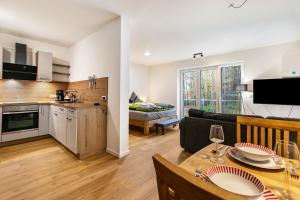 a kitchen and living room with a table and a couch at Grötacker Wohnung 6 in Husby