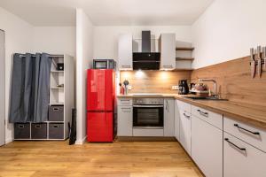 a kitchen with a red refrigerator and white cabinets at Grötacker Wohnung 6 in Husby +6 photos