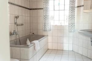a white bathroom with a tub and a sink at Ferienhaus Steinhoff in Marsberg