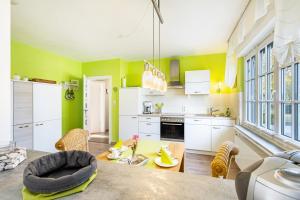 a kitchen with green walls and a table and chairs at Ferienwohnung Sommersonne in Warstein