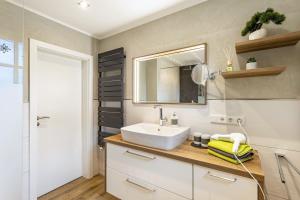 a bathroom with a sink and a mirror at Ferienwohnung Sommersonne in Warstein +20 photos