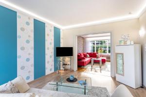 a living room with a couch and a tv at Ferienwohnung Sommersonne in Warstein