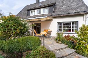 a house with a patio with a table and chairs at Ferienwohnung Sommersonne in Warstein