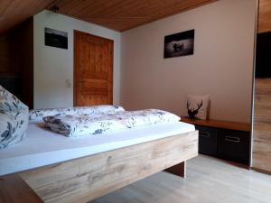 a bedroom with a bed with a wooden frame at Ferienwohnung Schwarzwaldfeder in Todtnau