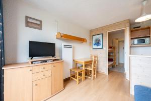 a living room with a television and a table with chairs at Studio Avec Vue Splendide in Villarembert +15 photos