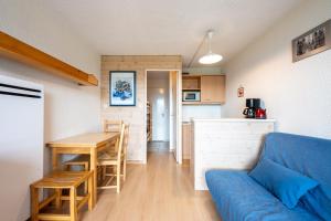 a living room with a blue couch and a table at Studio Avec Vue Splendide in Villarembert