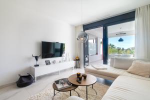 a living room with a couch and a tv at Ground floor 2bed Miradores del Sol in Estepona