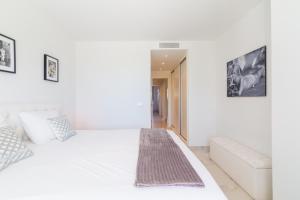a white bedroom with a bed and a couch at Ground floor 2bed Miradores del Sol in Estepona +17 photos