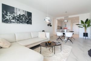 a living room with a white couch and a table at Ground floor 2bed Miradores del Sol in Estepona