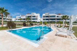 a swimming pool in front of a large apartment building at Ground floor 2bed Miradores del Sol in Estepona